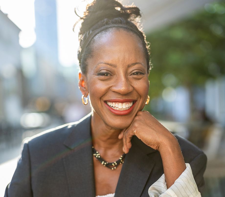 Smiling woman with professional attire outdoors.